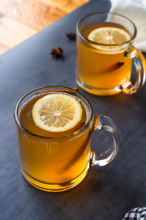 Beni's Toddy de Invierno - tazas de vidrio con bebida caliente, limón y especias